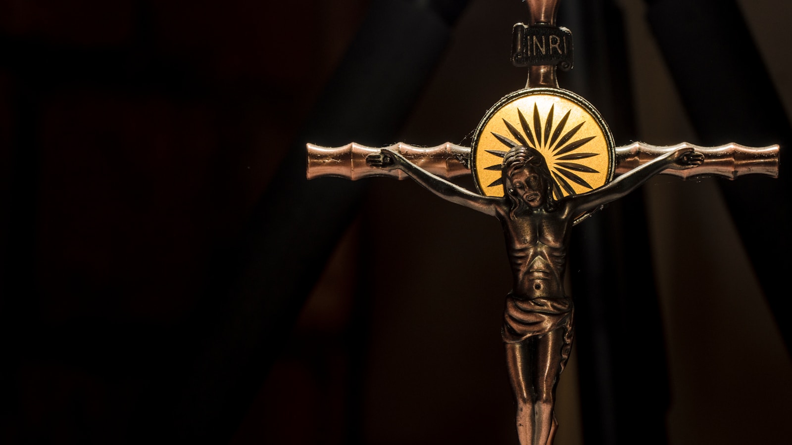 a crucifix with the sun shining through it